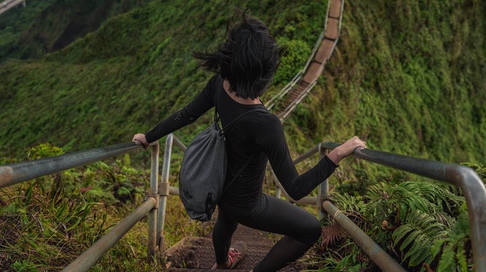 Woman looking over steep stairs on a mountain