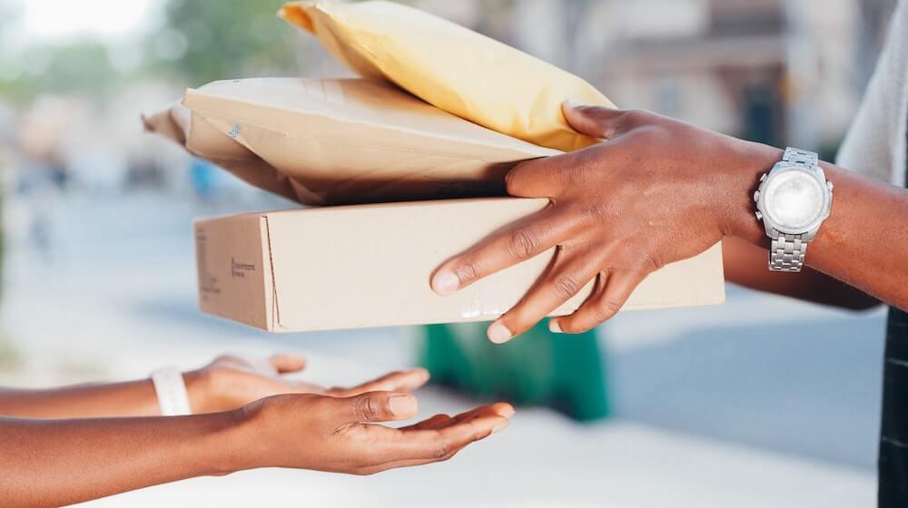 One person handing off packages to another person