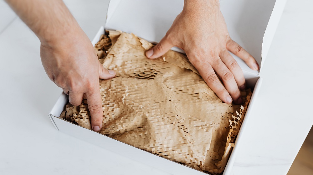 Person packing a shipping box