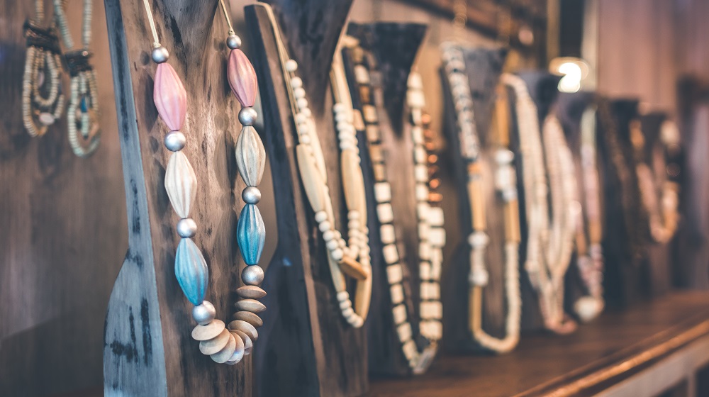 Row of necklaces displayed on wooden stands