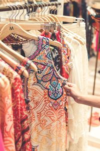 Person browsing through colorful clothing racks
