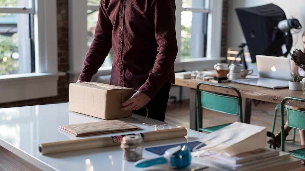 Close-up of person handling package on table