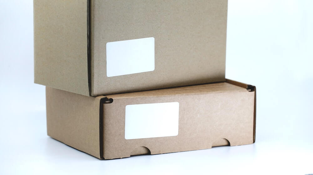 Two shipping boxes with blank white labels-2