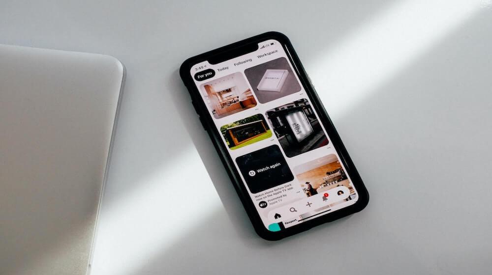 Mobile phone with Pinterest feed on screen