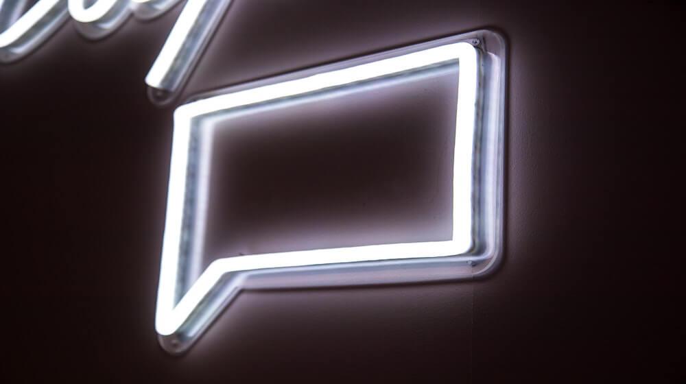 Neon sign in the shape of a square chat bubble