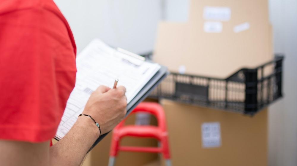 Person marking checklist on clipboard