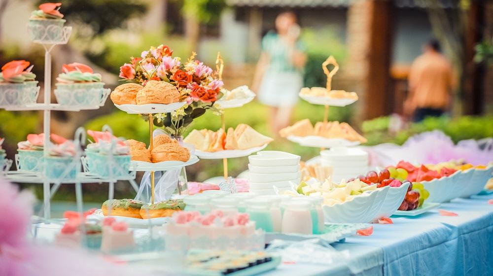 Finger foods set out on a long banquet table outdoors