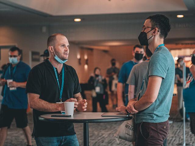 Two people chatting at a table in the halls of WCUS 2022-2