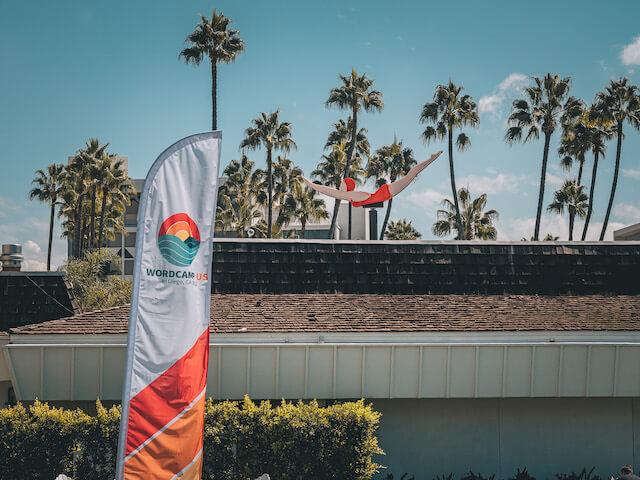 WordCamp 2022 flag posted in front of outdoor setting with palm trees-2