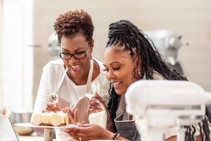 the cheesecake sisters looking at their phone in the kitchen