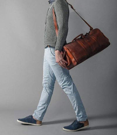 Person carrying leather duffel bag