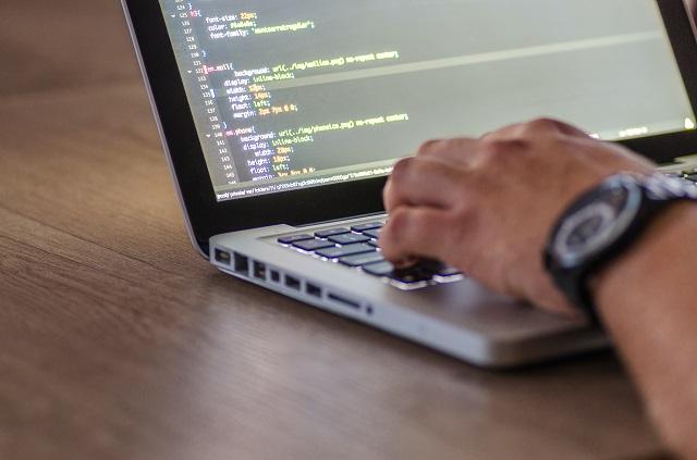 A laptop displaying CSS code resting on a table