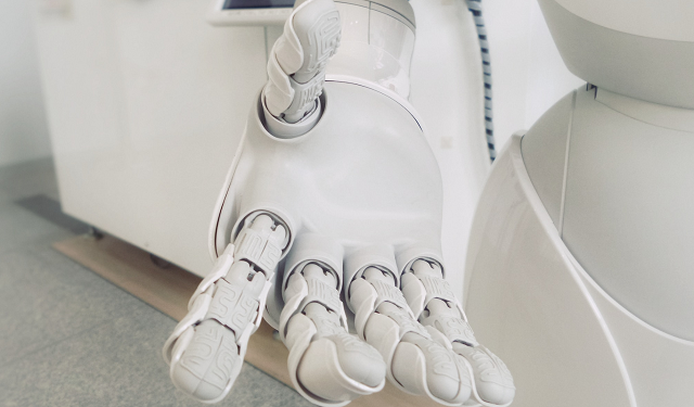 Picture of a white robotic hand, palm open, outstretched