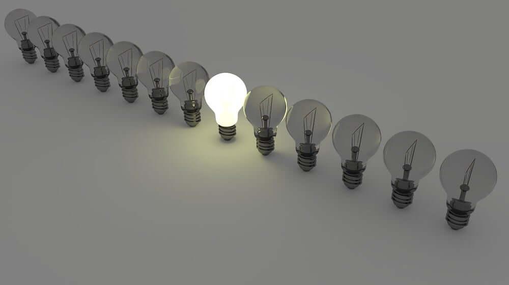 Row of lighbulbs with only one turned on in the center-2