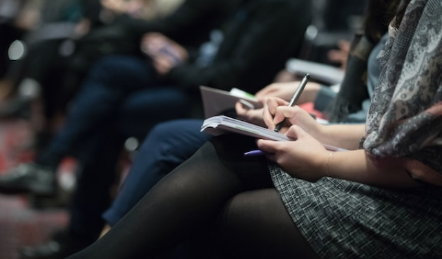 Woman sitting in a meeting taking notes