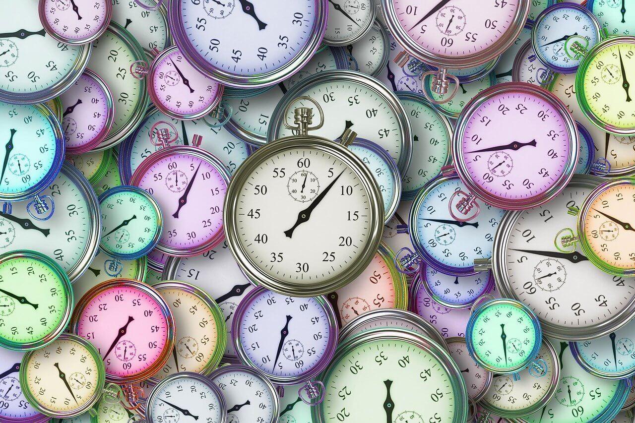 Pastel colored clocks scattered together as a background(1)