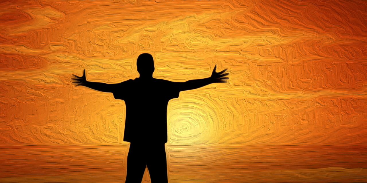 Silhouette of a man standing in front of sunset