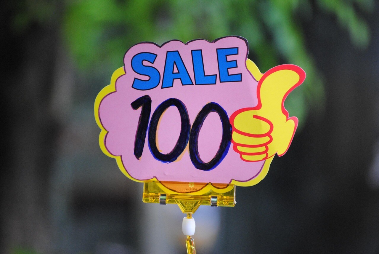 A Sign Advertises a Sale with a Thumbs-up Graphic