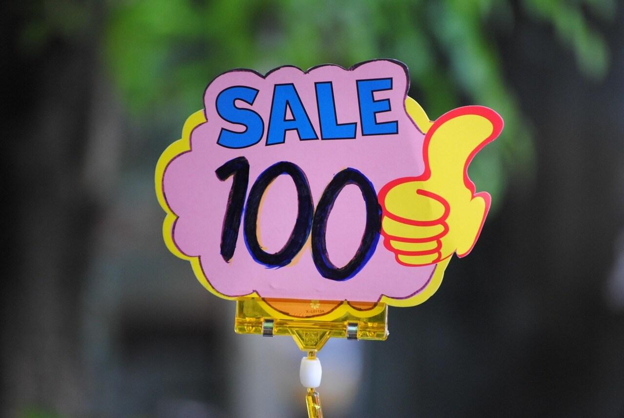 A Sign Advertises a Sale with a Thumbs-up Graphic