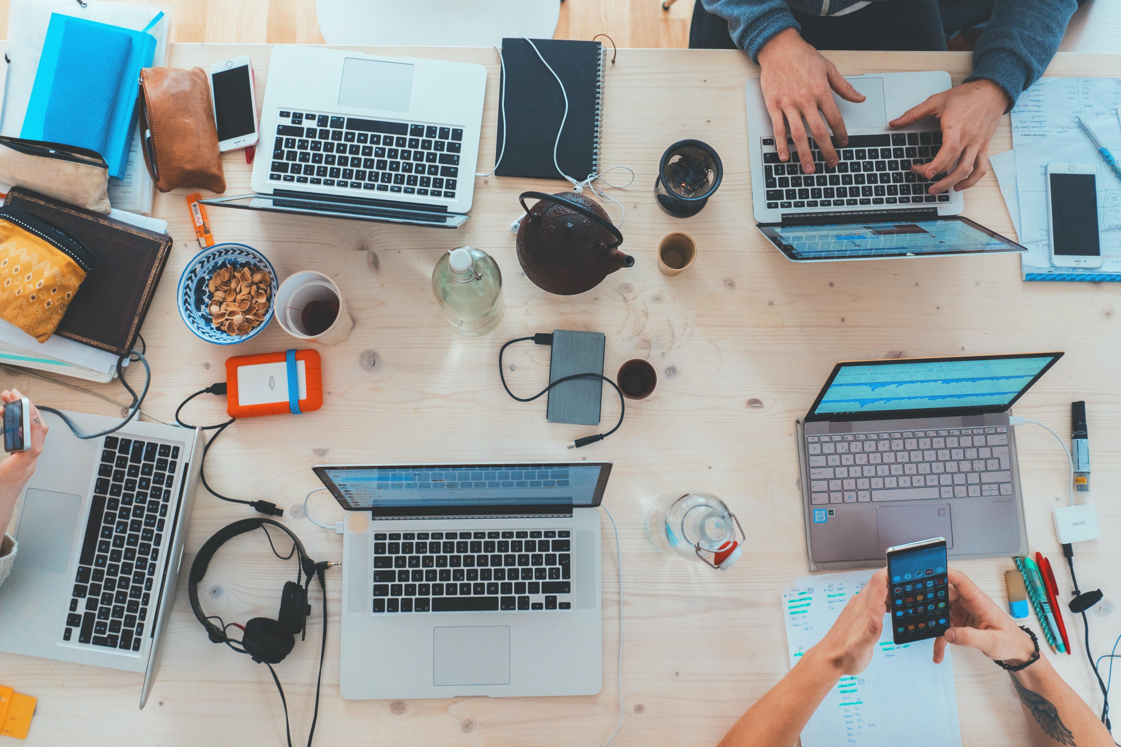 A group of people sitting at a table with laptops