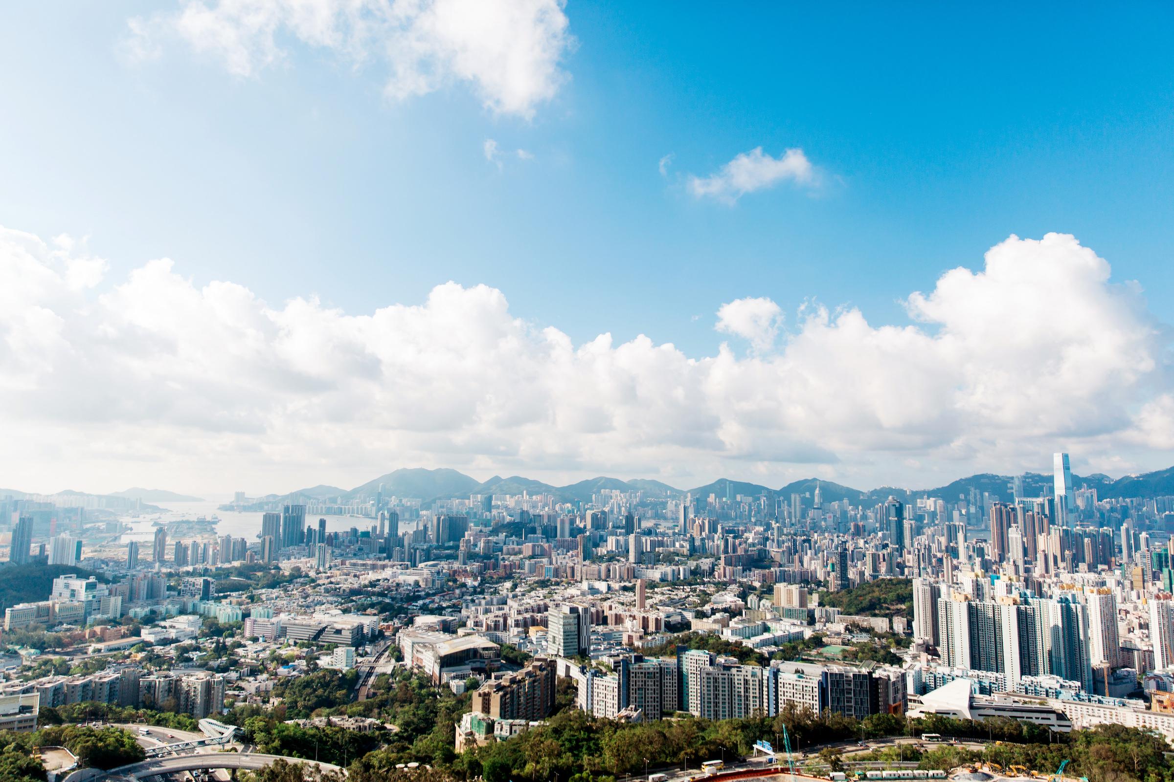 A charming scene of a city nestled amidst mountains and adorned with clouds