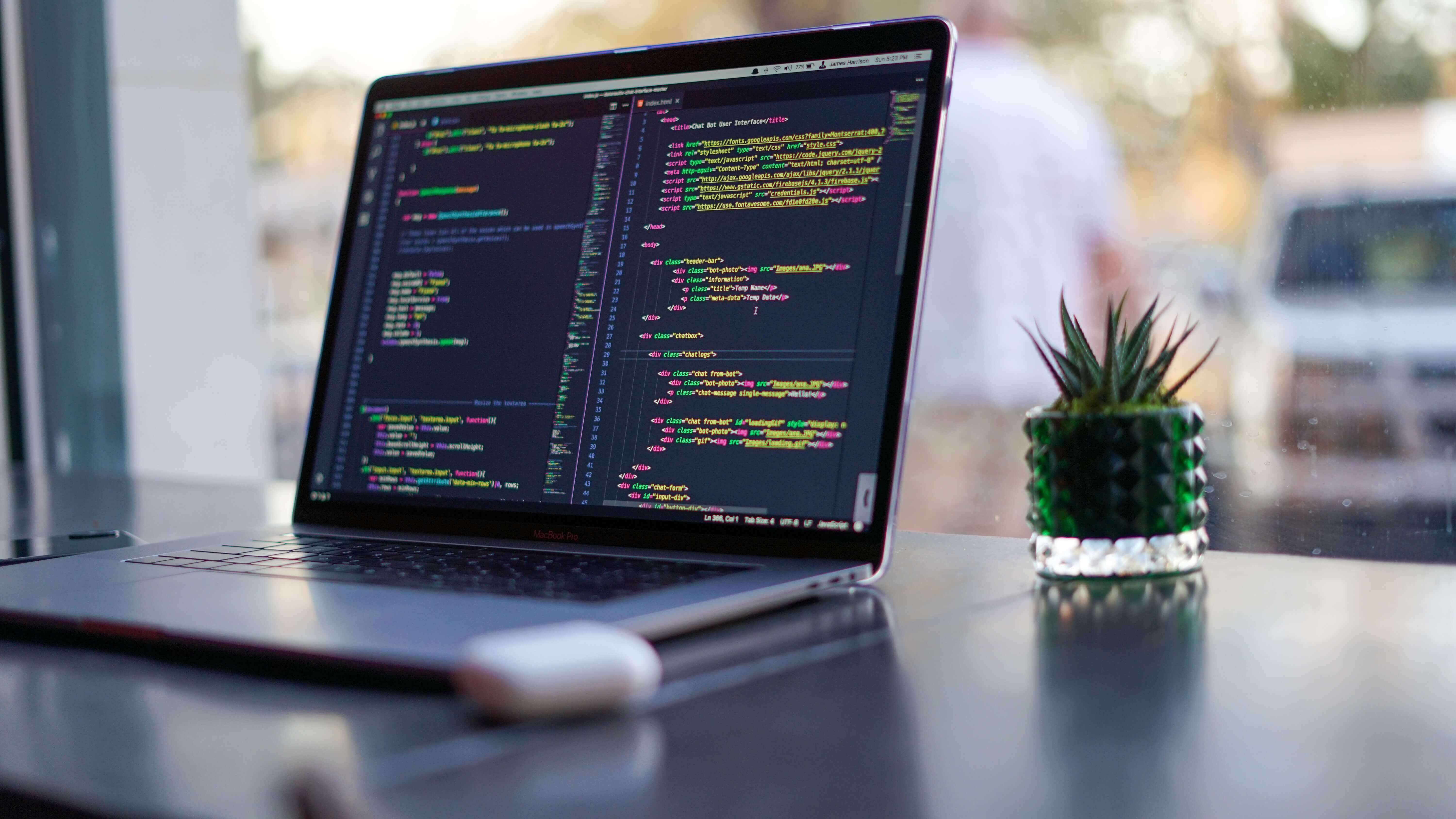 A laptop with colorful code on screen