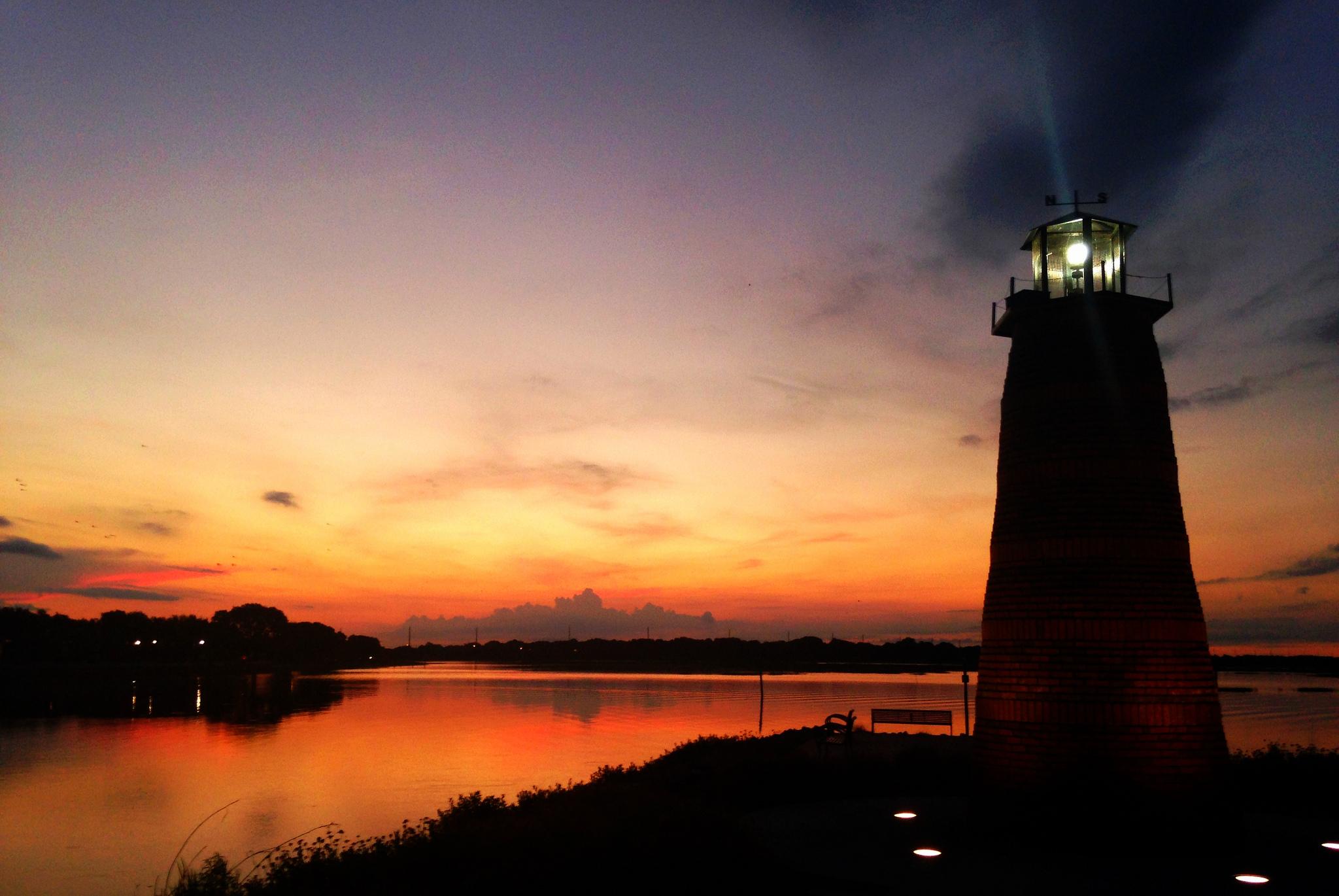 A lighthouse with a light on top and a body of water