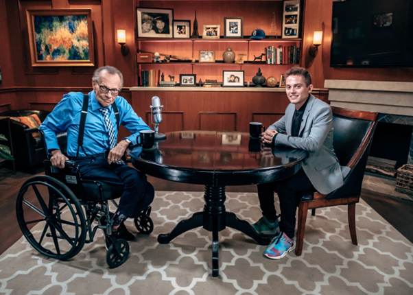 Casey Adams and Larry King sitting at a table