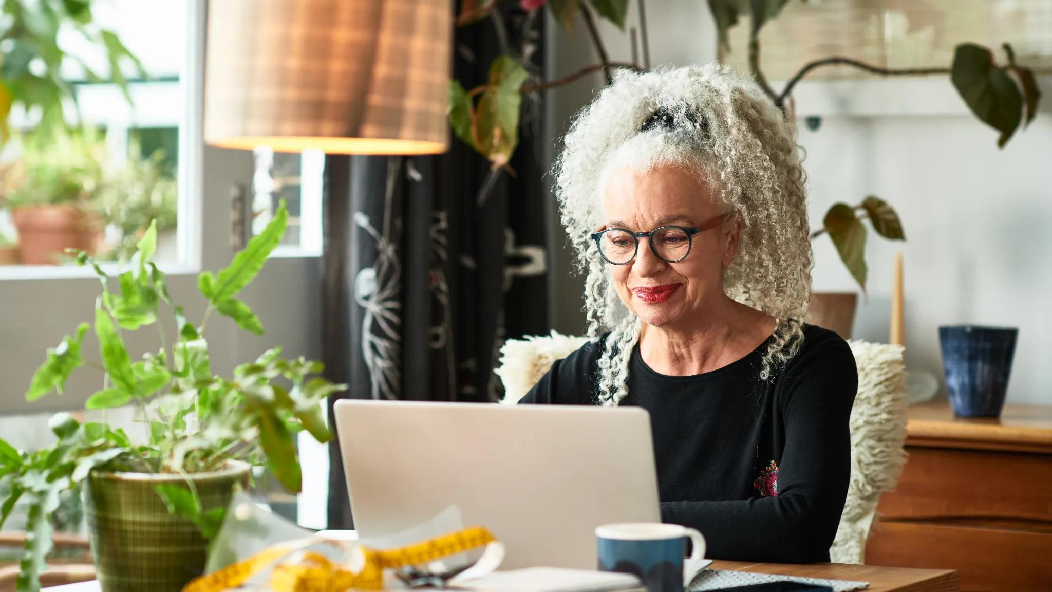 Woman sitting at a desk, working on a laptop.