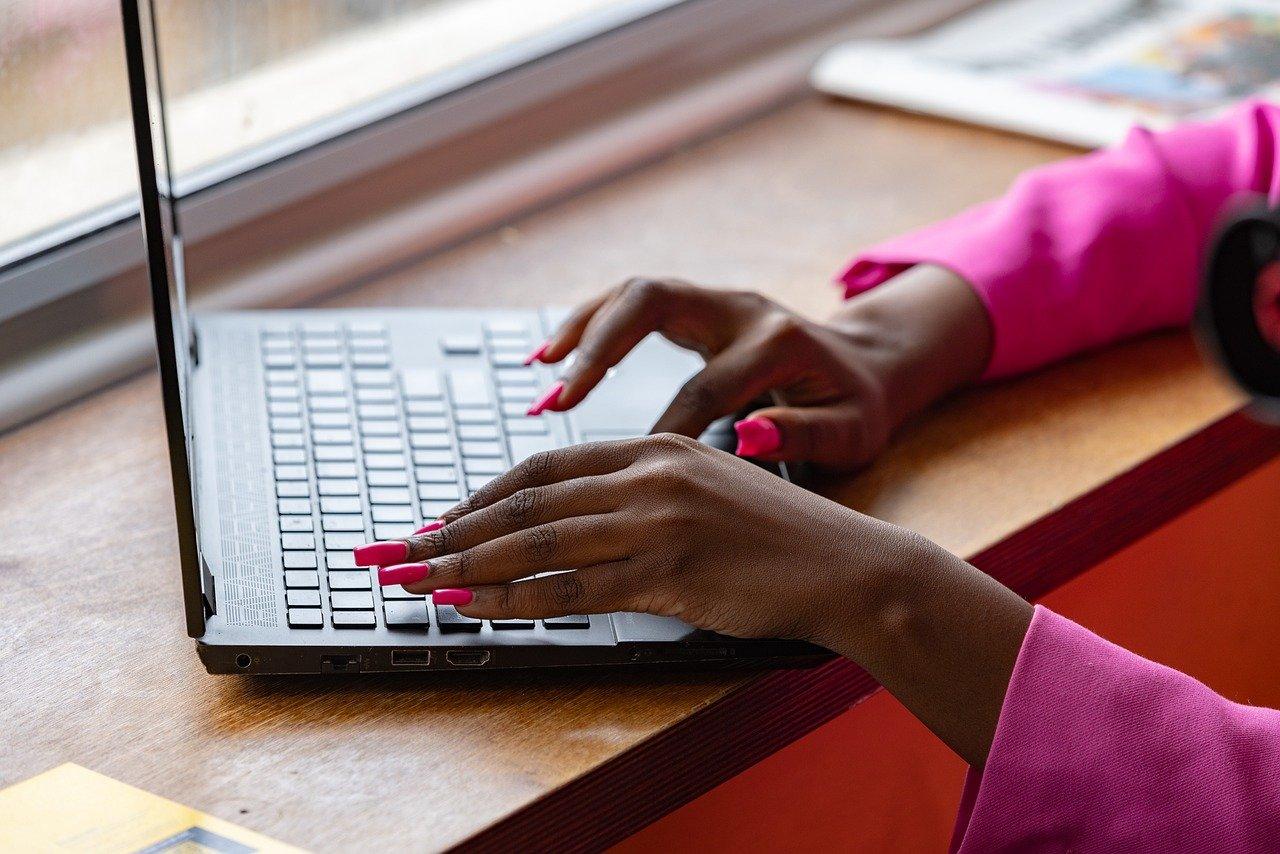 Two Female Hands Work on a Laptop