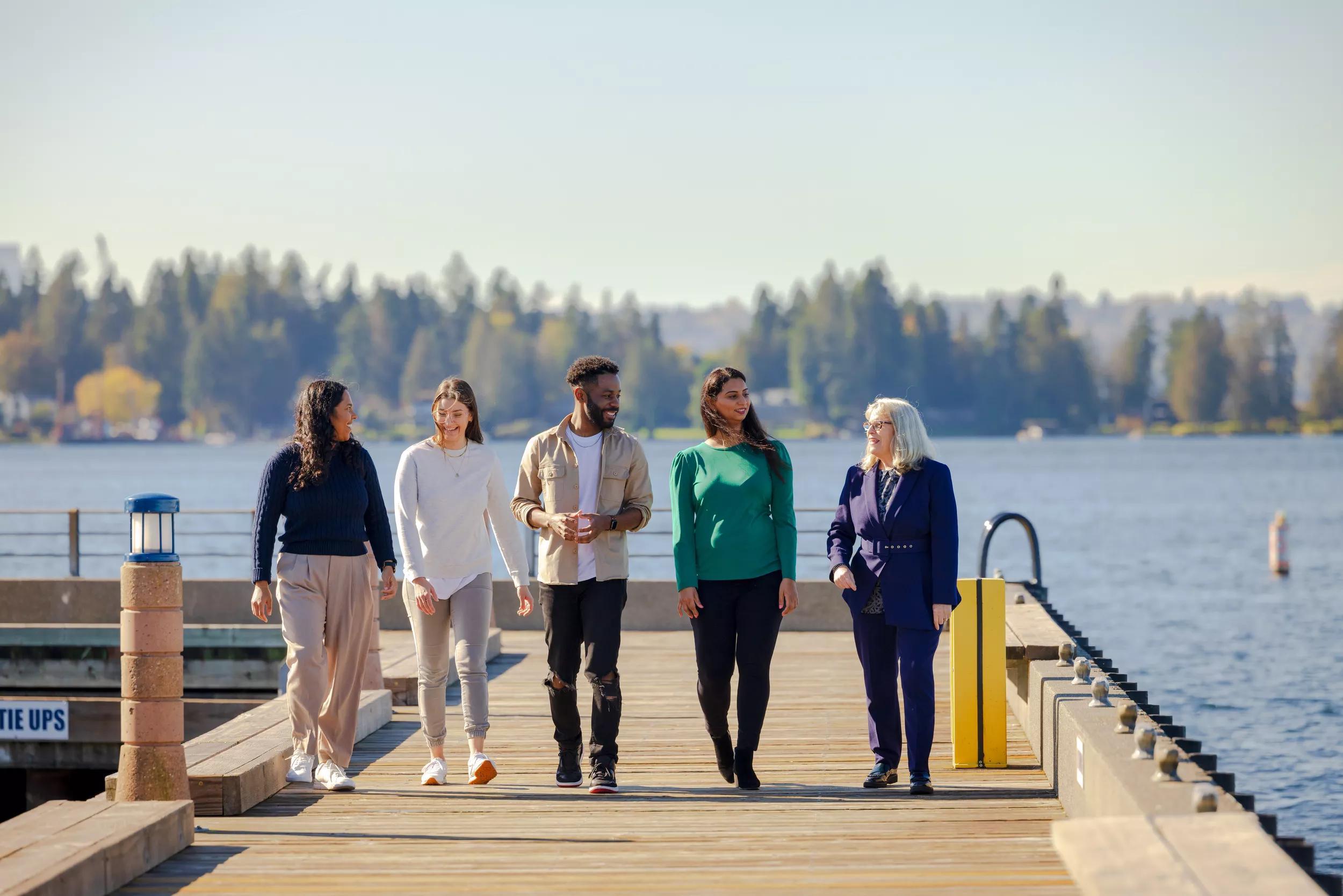 a group of people standing on a dock by a body of water