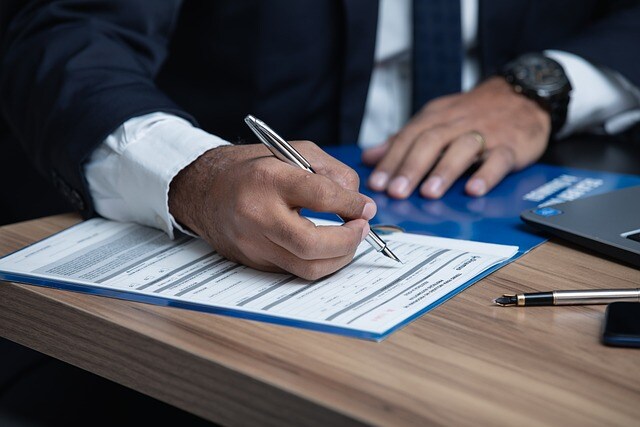 LLC California Man Wearing Suit Filling Out Paperwork with Silver Pen