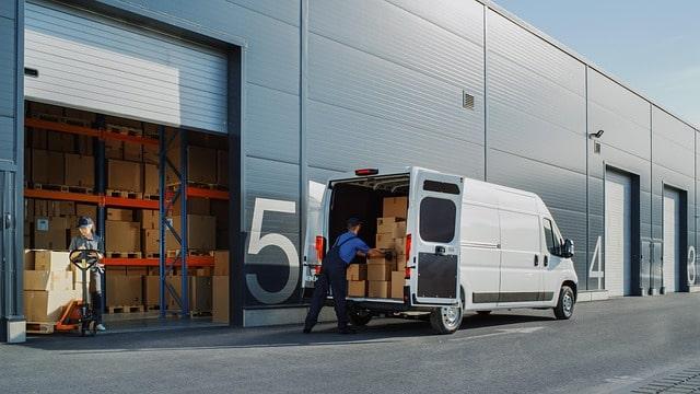 Catalog Management Man and Woman Packing Inventory in Van