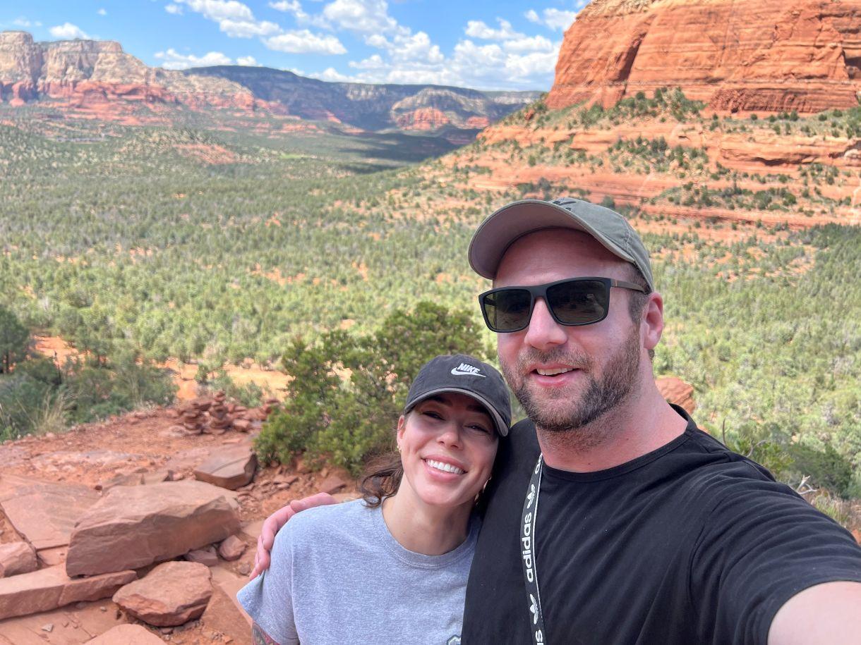 a man and woman posing for a picture in front of a canyon