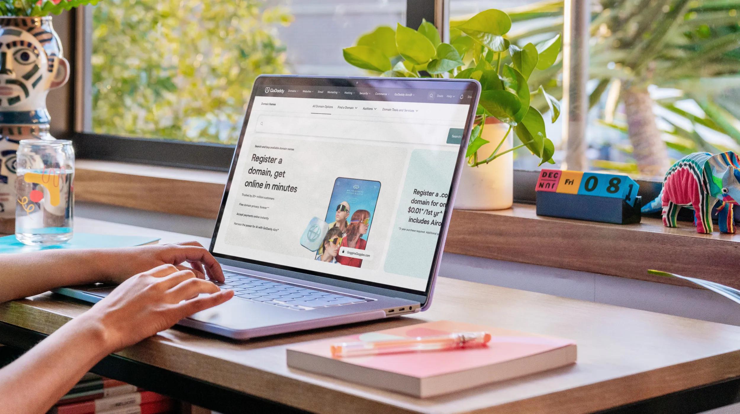 Person browsing a laptop on a desk, looking at a website that highlights domain registration options beyond .com/best .com alternatives for entrepreneurs seeking the perfect web address for their business across various industries.