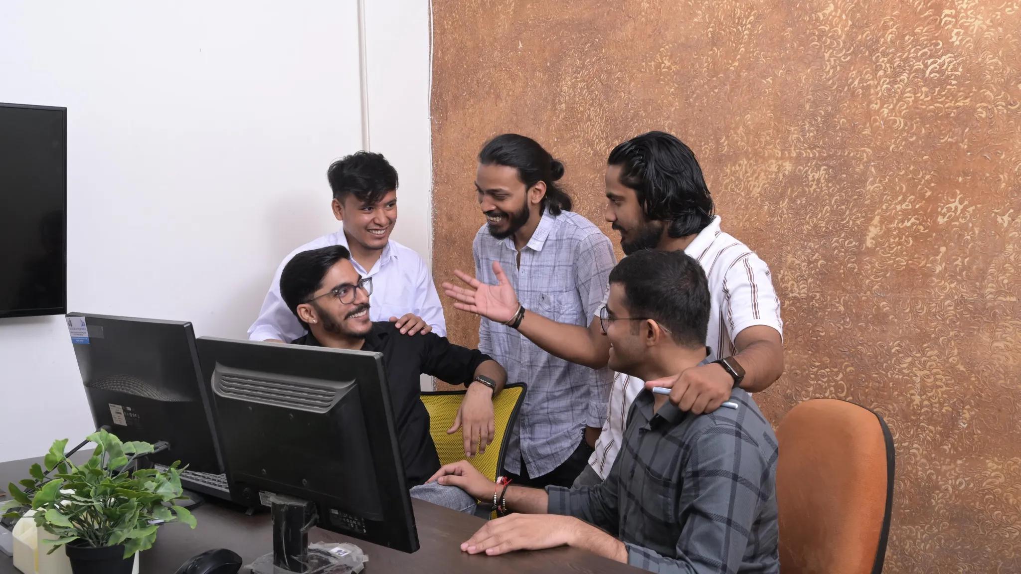 a group of men looking at a computer screen