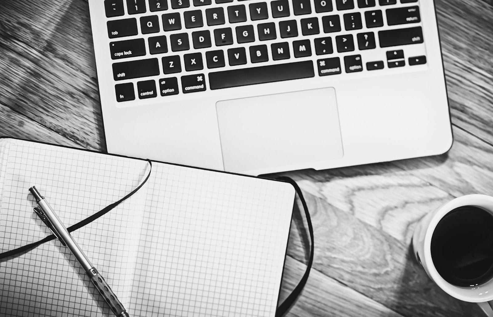 An Overhead Shot of a Laptop and Notebook