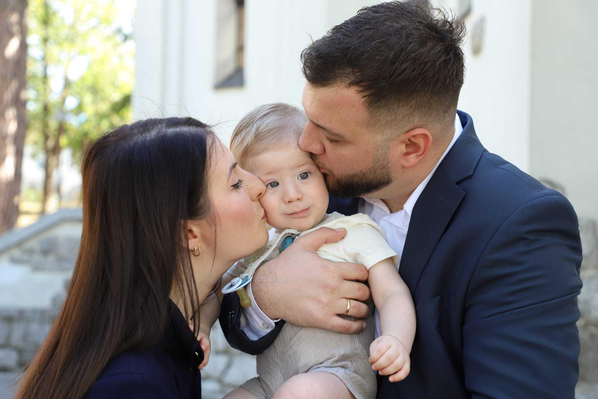 a man and woman holding a baby