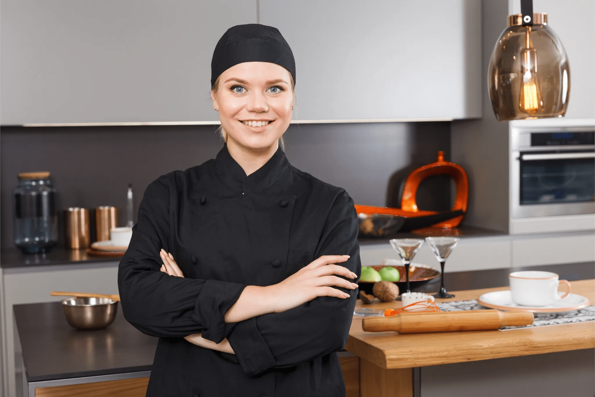 Chef standing in a home kitchen with a meal prepared behind her.