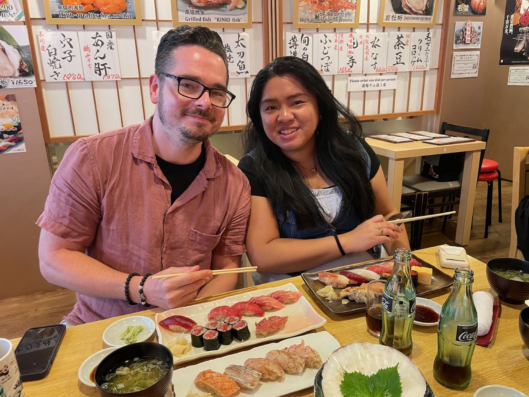 a man and woman sitting at a table with food