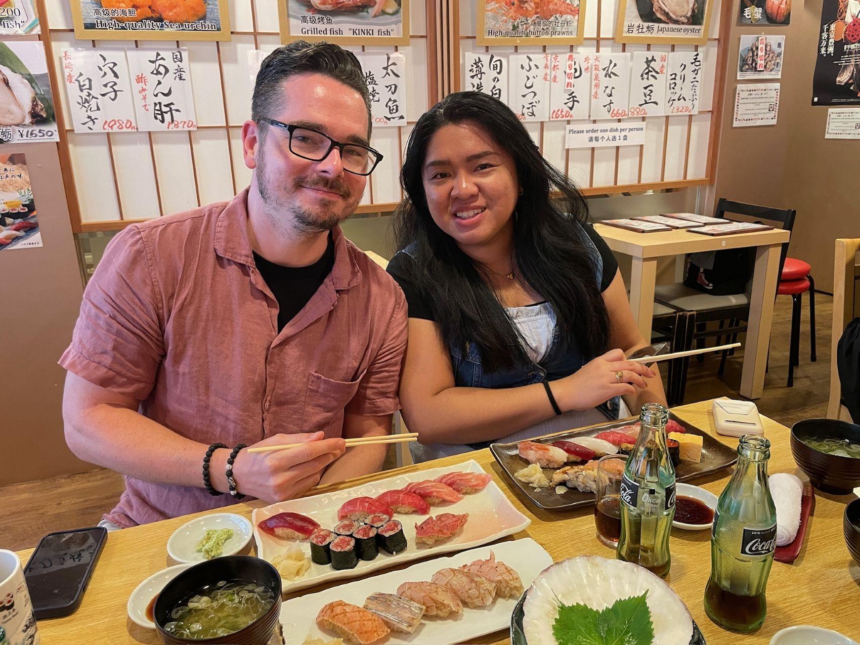 a man and woman sitting at a table with food
