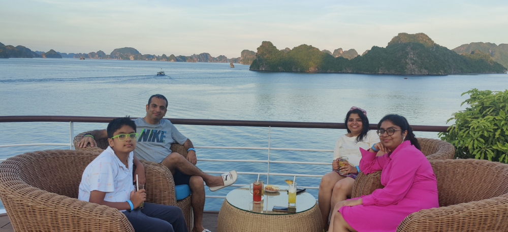 a group of people sitting on a deck overlooking a body of water