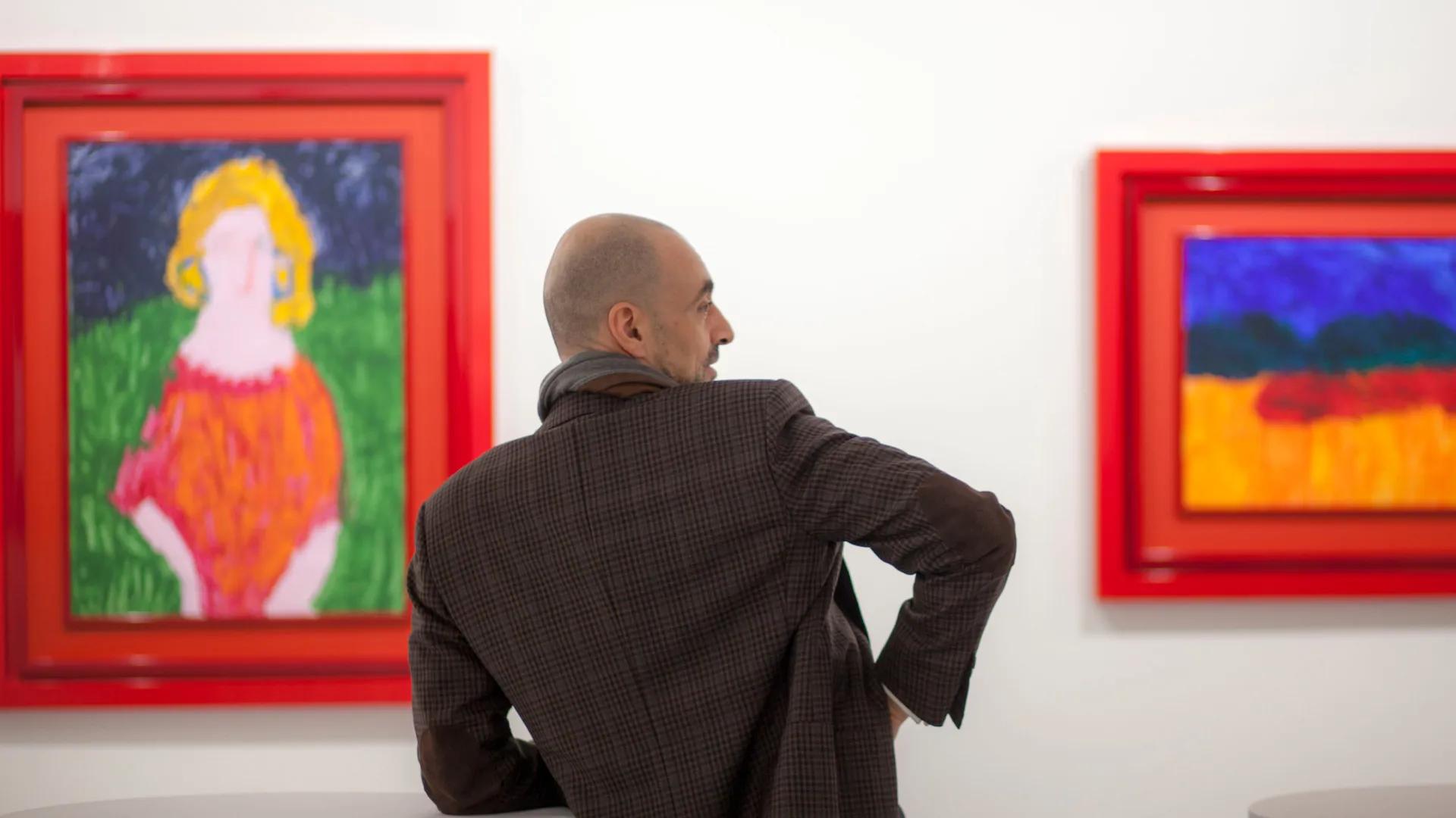 .art Founder Ulvi Kasimov Stands in a Gallery, paintings by .ART's official artist medina.art