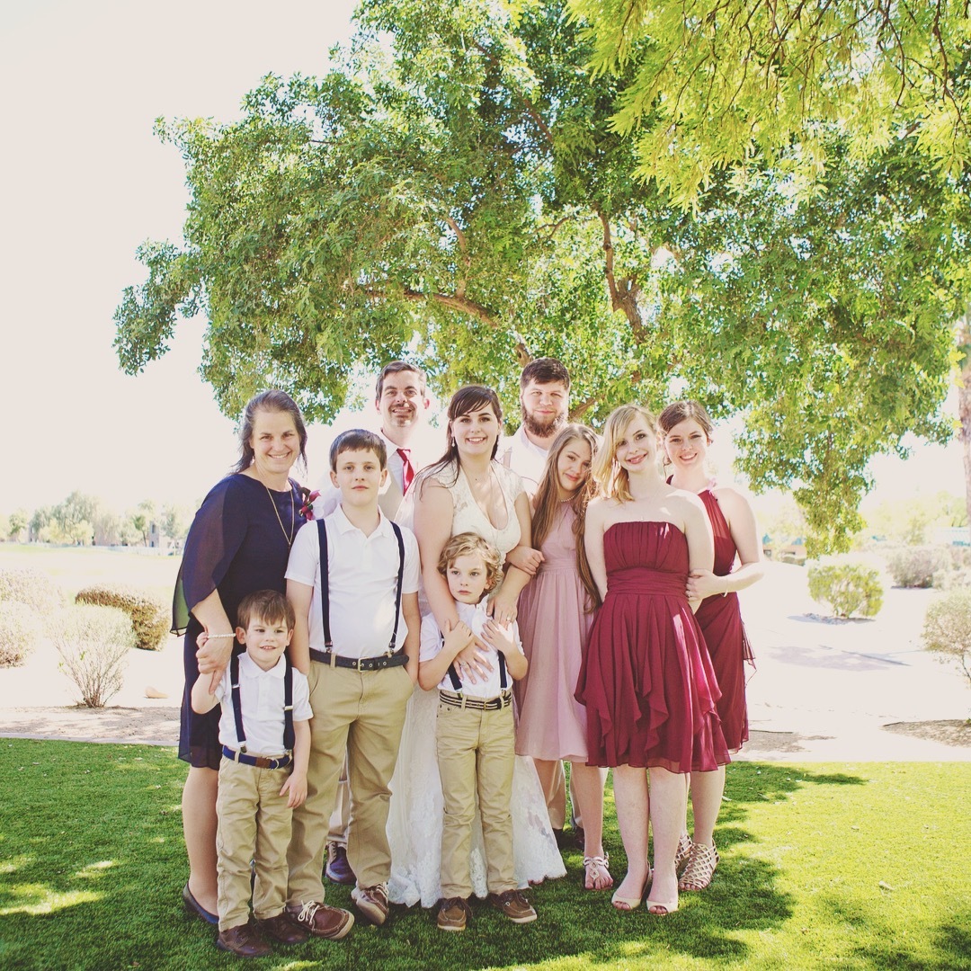 a group of people posing for a photo under a tree