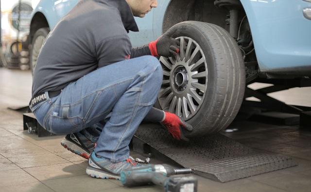 Mechanic Changing Car Tire In Repair Shop