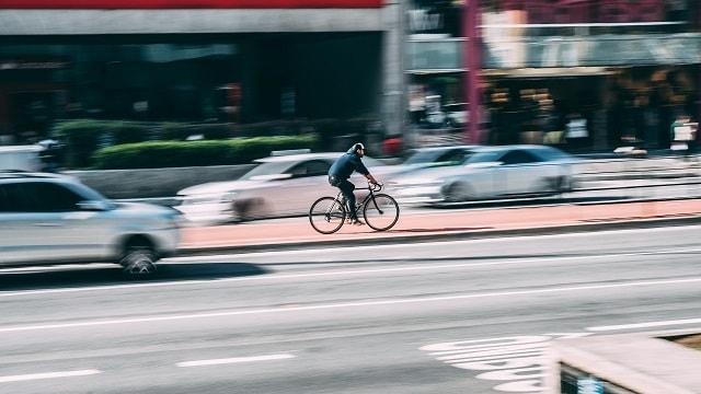 Bicycle Traffic Surrounded by Speeding Cars