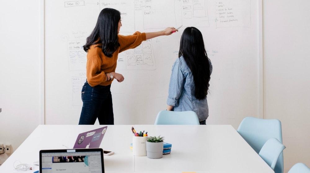 Client Onboarding Women Discussing Whiteboard