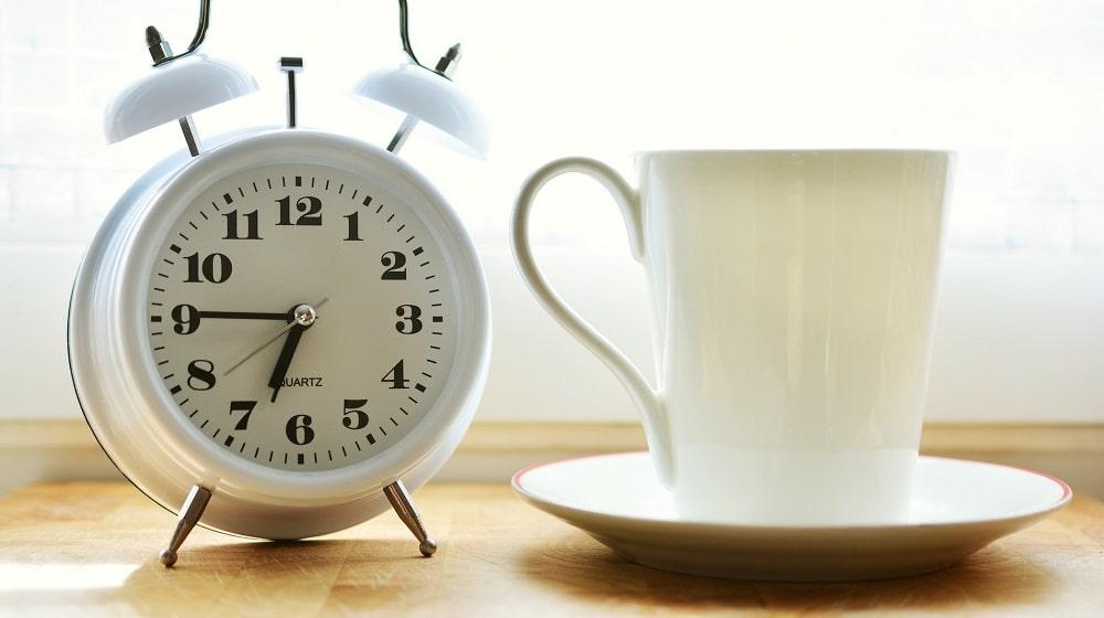 Clock Sitting Near Coffee Mug Illustrates Creating First Newsletter Fast