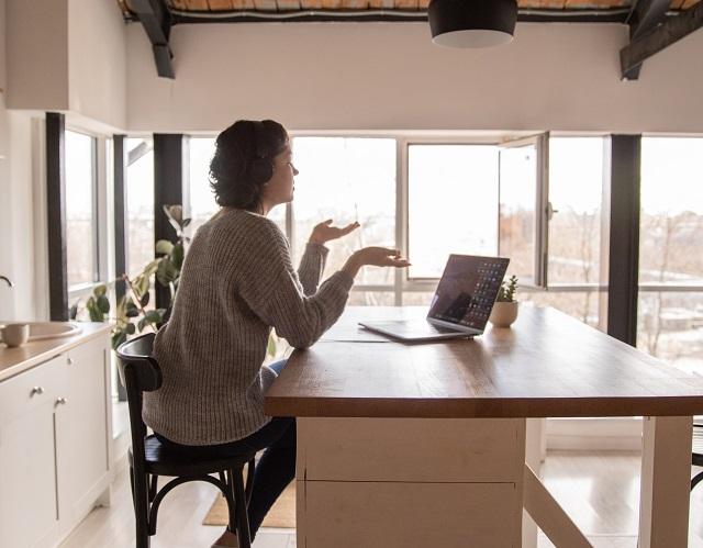 Woman Wearing Headphones Having Conversation On Laptop