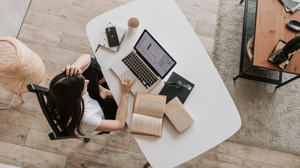 Woman Sitting At A Desk To Create A Social Media Strategy